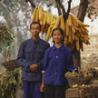Bauernpaar vor geernteten Maiskolben